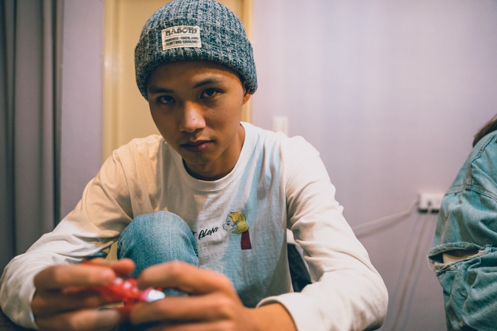 person in blue beanie leaning on desk