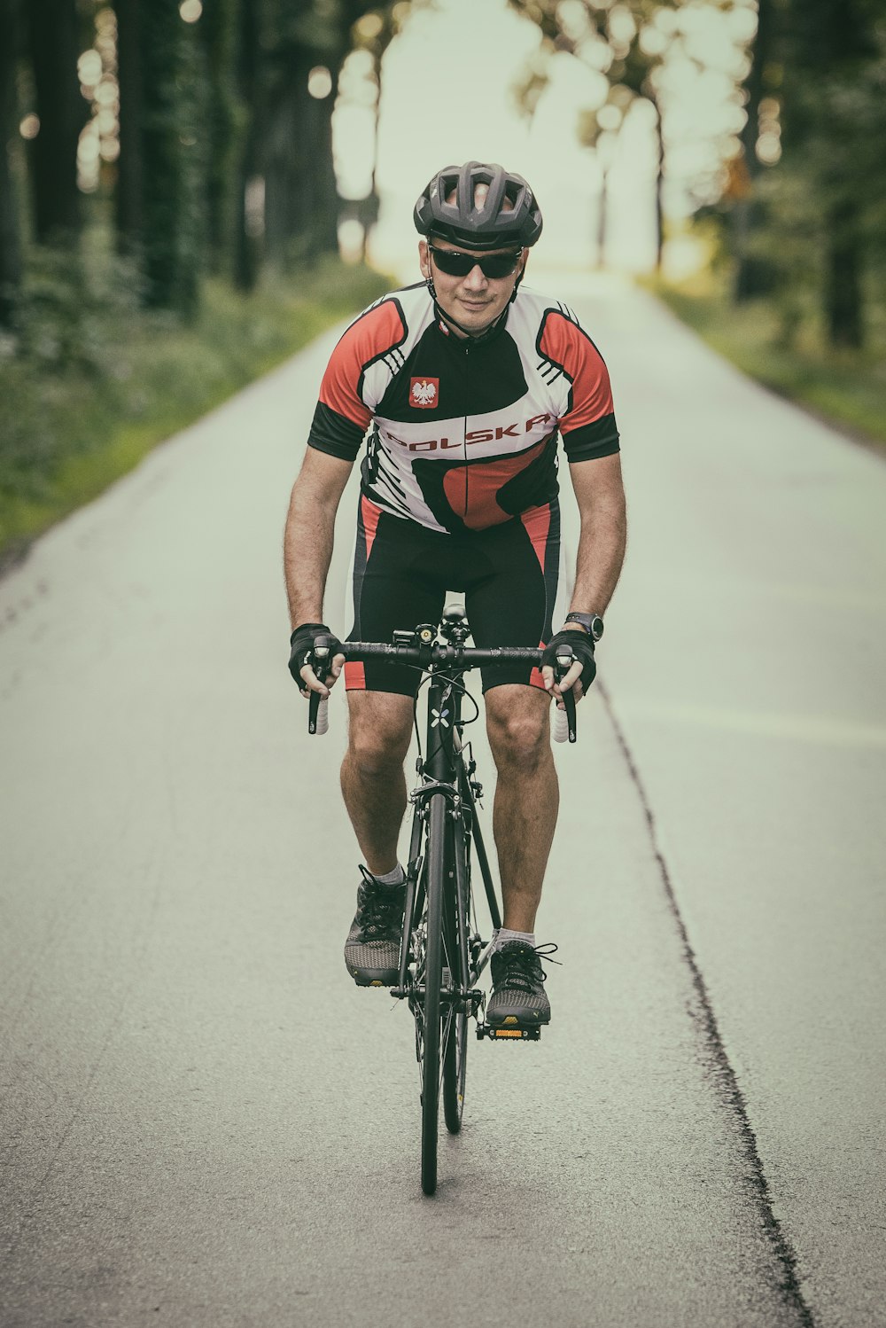 man riding road bike on concrete road during daytime