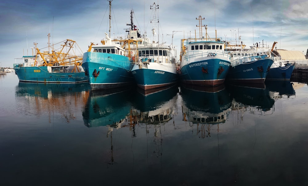 six blue-and-white boats on body of water during daytime