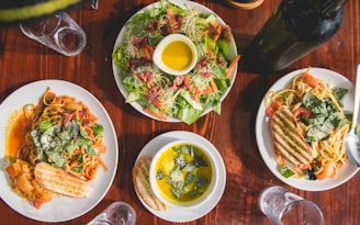 four assorted dishes on wooden surface