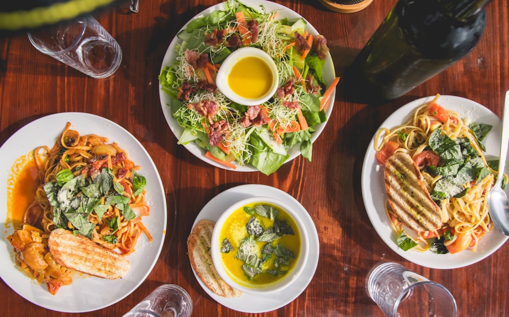 four assorted dishes on wooden surface