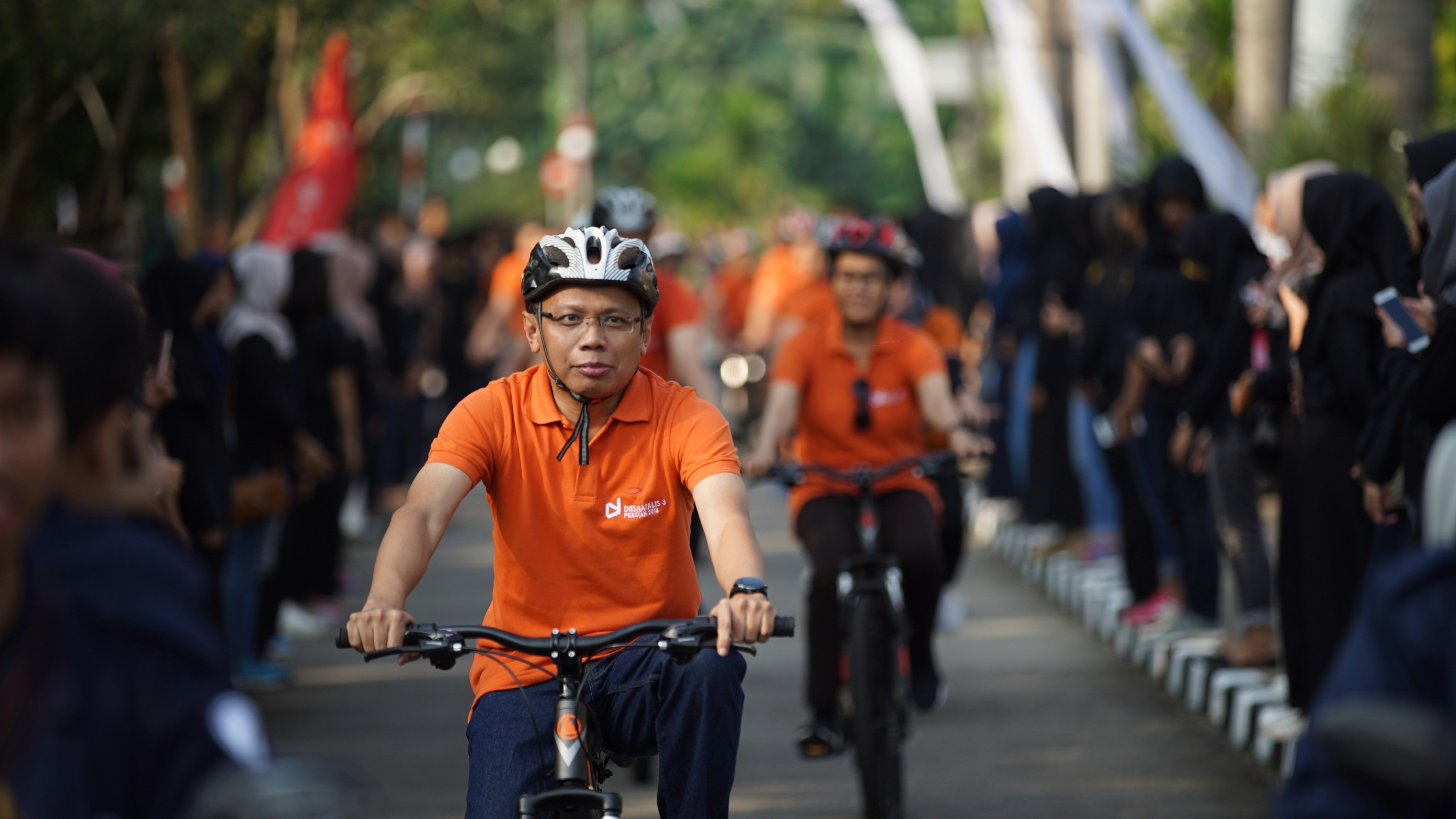 एक नेता का चित्र, जो लोगों के बीच घिरे हुए हैं और मुस्कुरा रहे हैं, संभवतः सुकांता नाइक जैसा दिखने वाला।