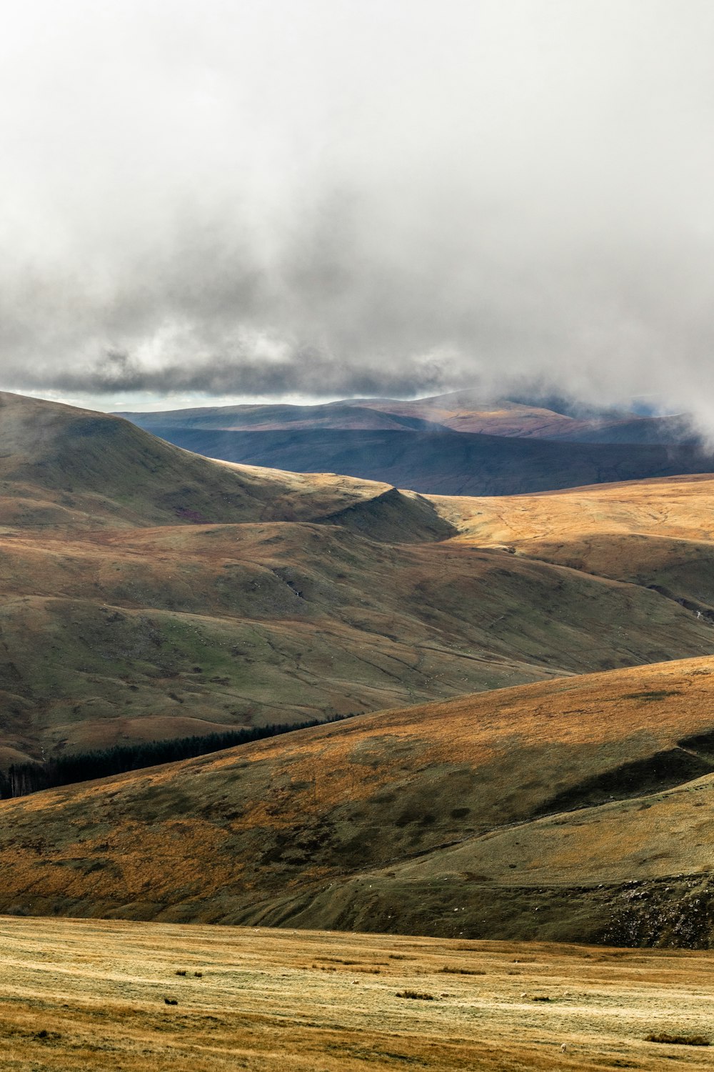 brown and green mountain under white cloudy sky