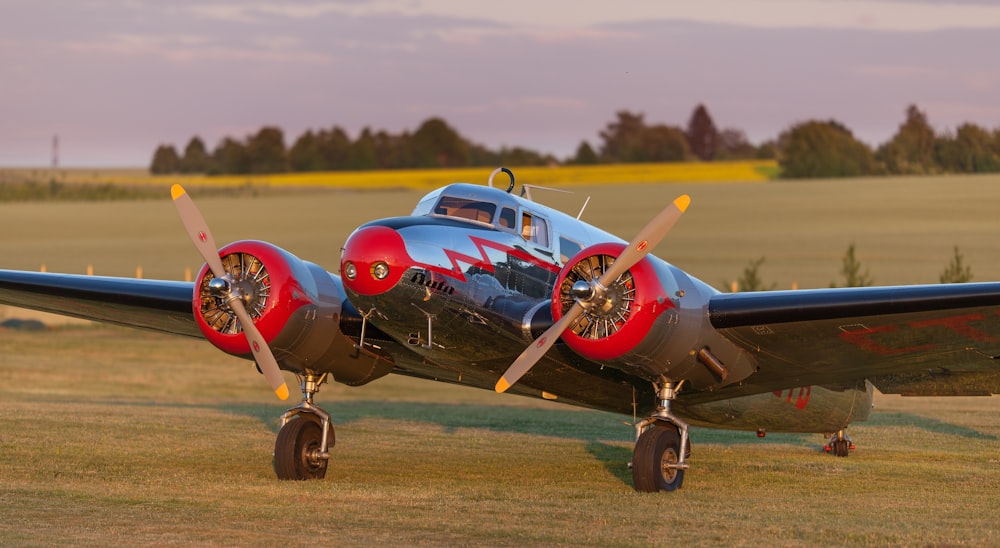 black and red monoplane on green grass field