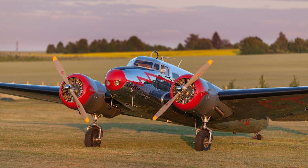 black and red monoplane on green grass field,