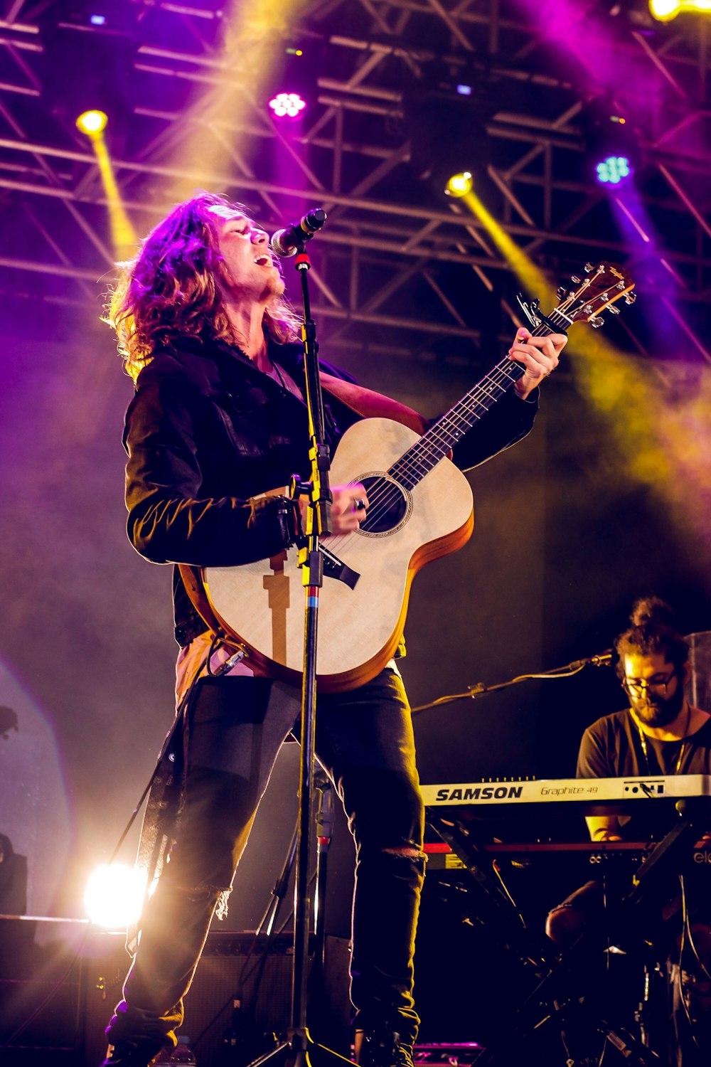 Mann singt und spielt Gitarre auf der Bühne