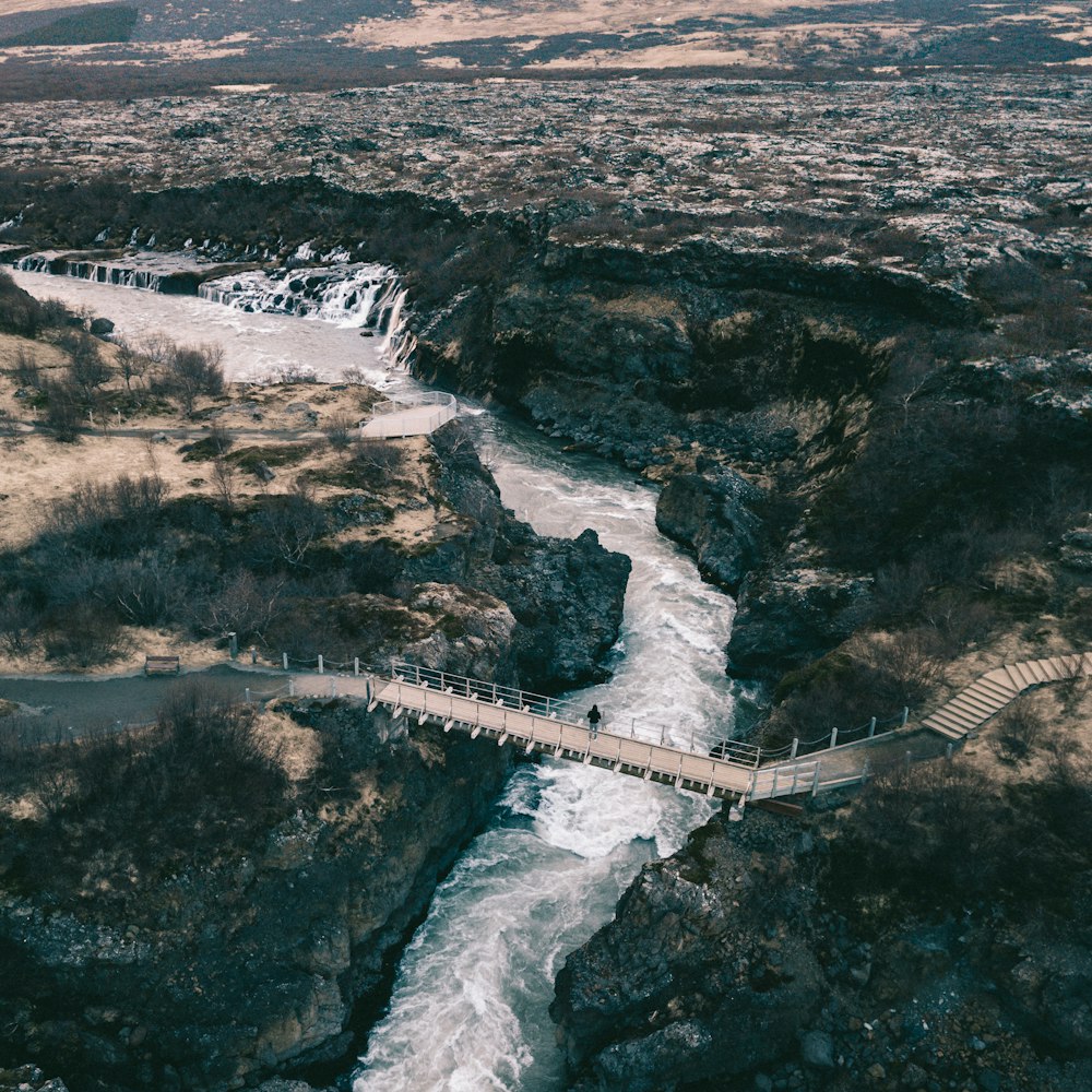 man standing on hanging bridge across the river