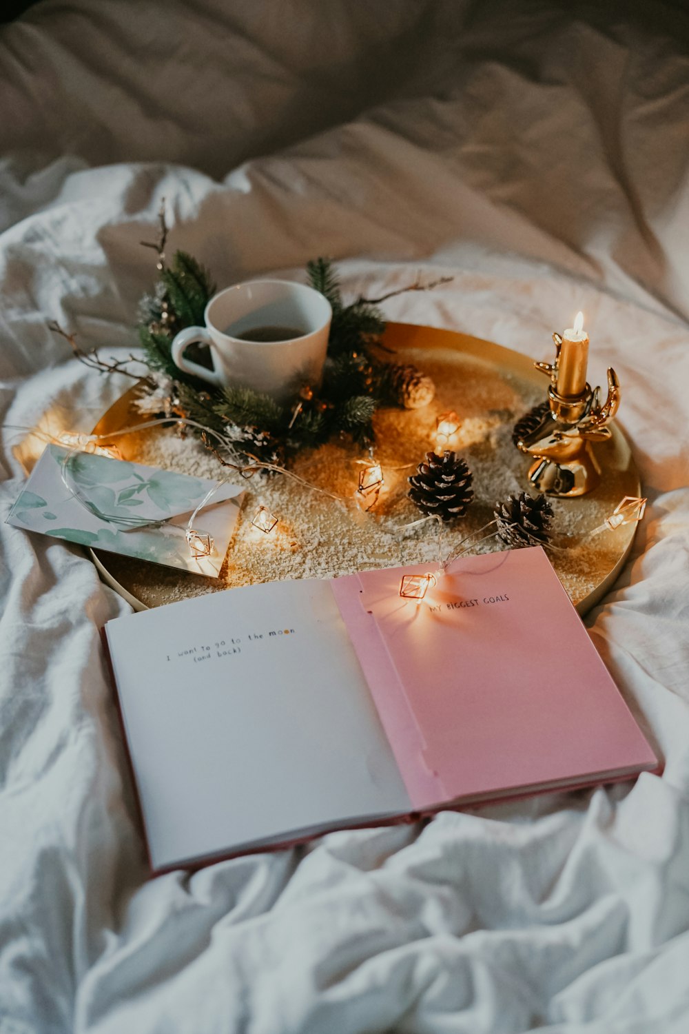 white ceramic teacup on serving tray and book