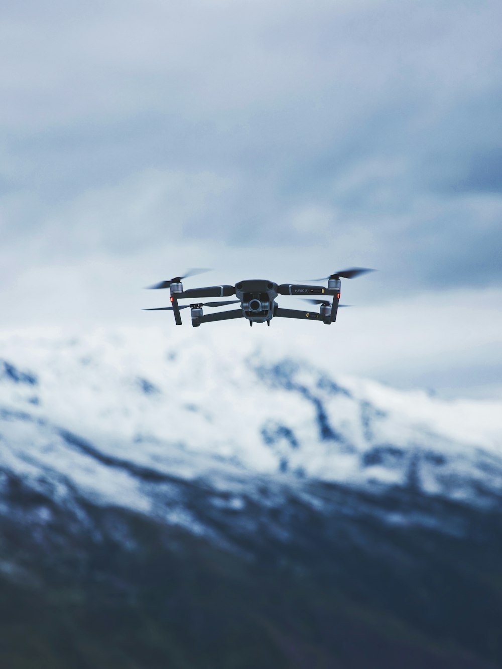 gray quadcopter drone under cloudy sky during daytime