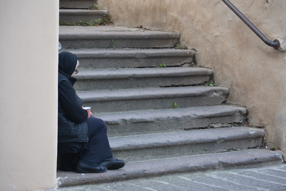 person sitting on stair during daytime