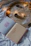 An open book with the words 'YOU are the BEST' on one page and 'A FAN LETTER TO MYSELF ...' on the other page is placed on a white cloth or bedspread. The background features a golden tray filled with white powder and decorated with small pinecones and a string of warm fairy lights.