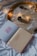 An open book with the words 'YOU are the BEST' on one page and 'A FAN LETTER TO MYSELF ...' on the other page is placed on a white cloth or bedspread. The background features a golden tray filled with white powder and decorated with small pinecones and a string of warm fairy lights.