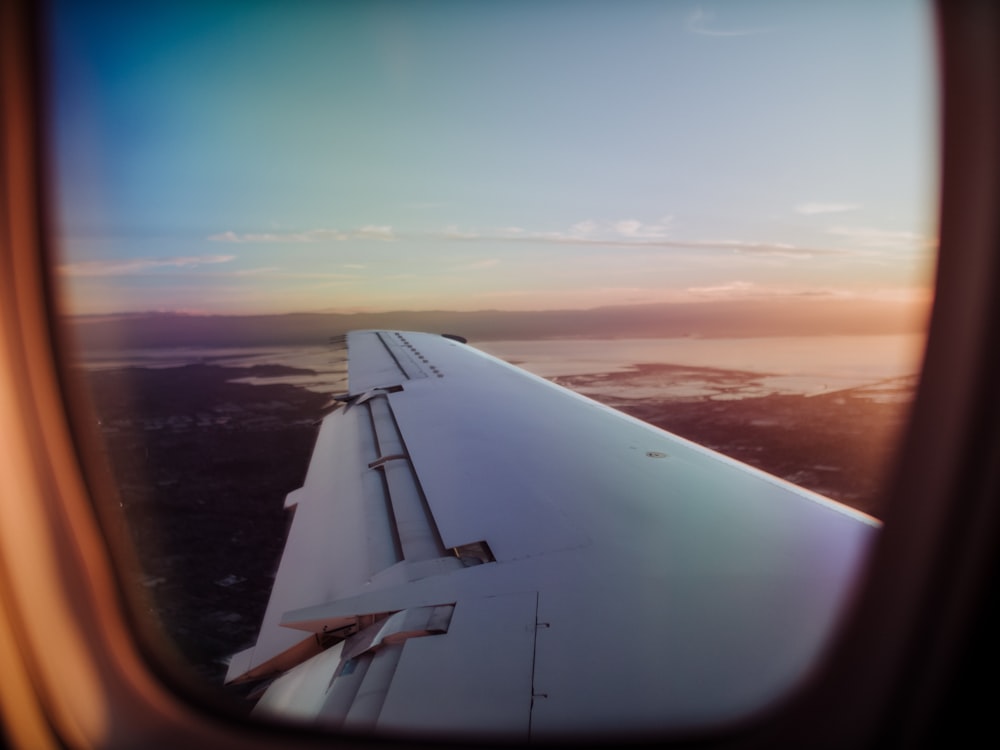 plane wing view on window at golden hour