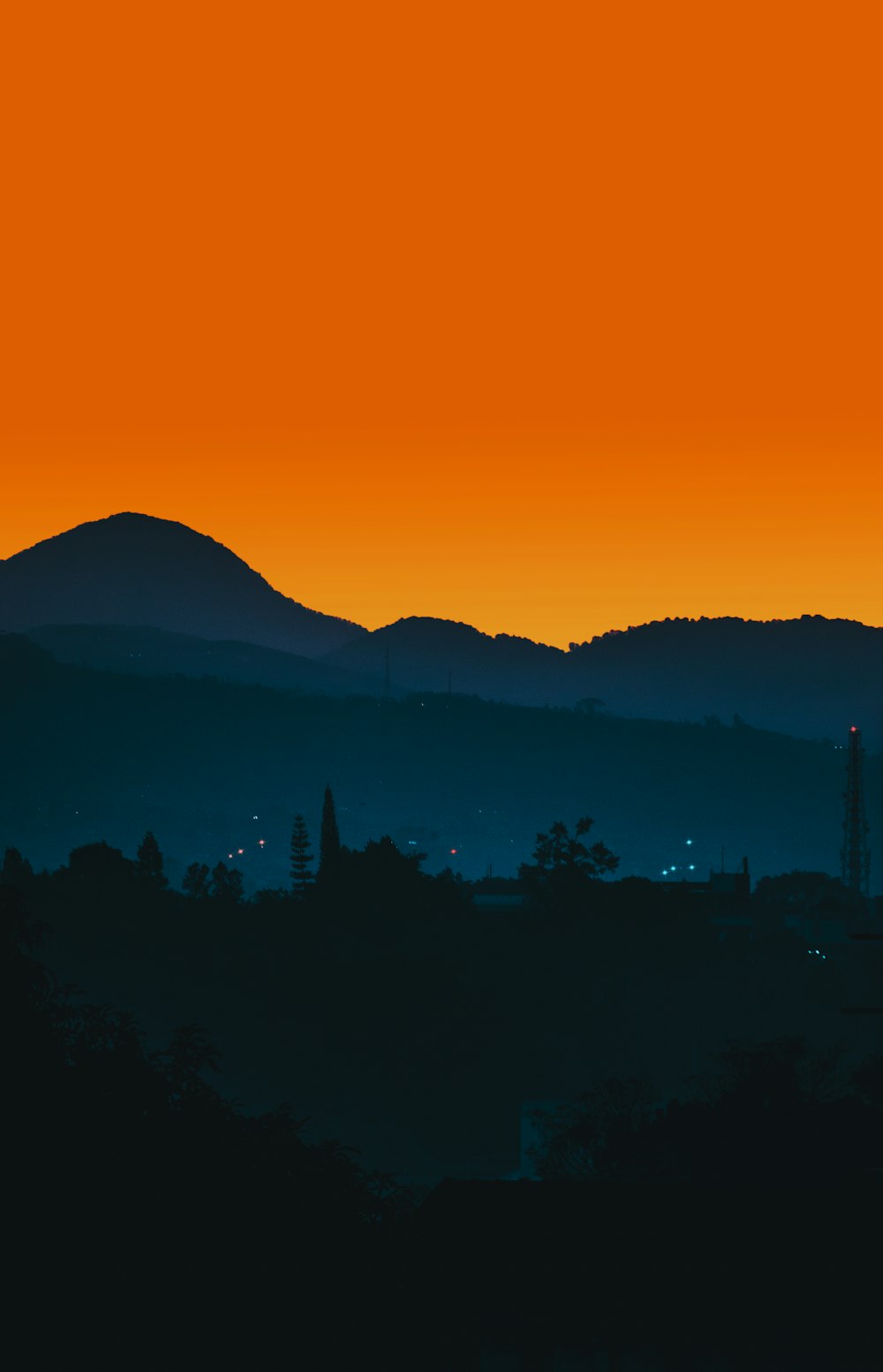 a plane flying over a mountain range at sunset