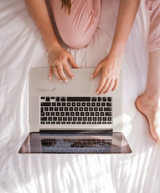 femme en visioconference sur son ordinateur portable , assise dans son lit