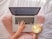person using MacBook Pro and holding cappuccino