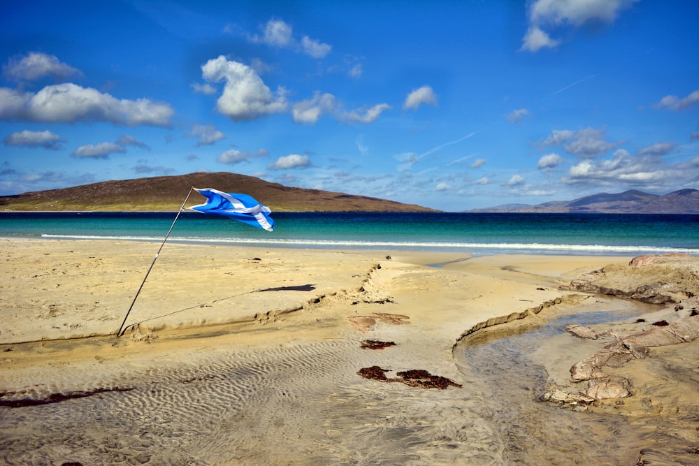 sand near ocean under blue sky