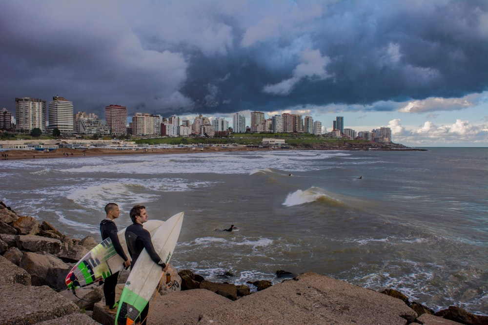 two men carrying surfboard