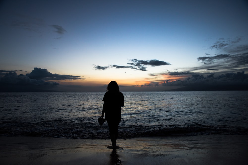 silhouette of woman on seashore