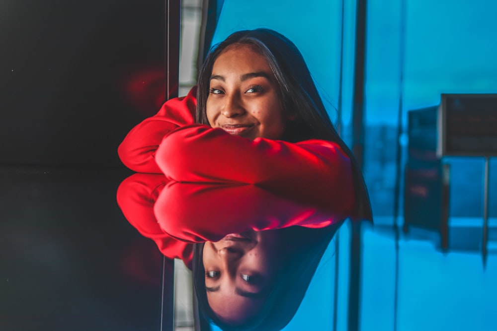 smiling woman leaning on mirror surface