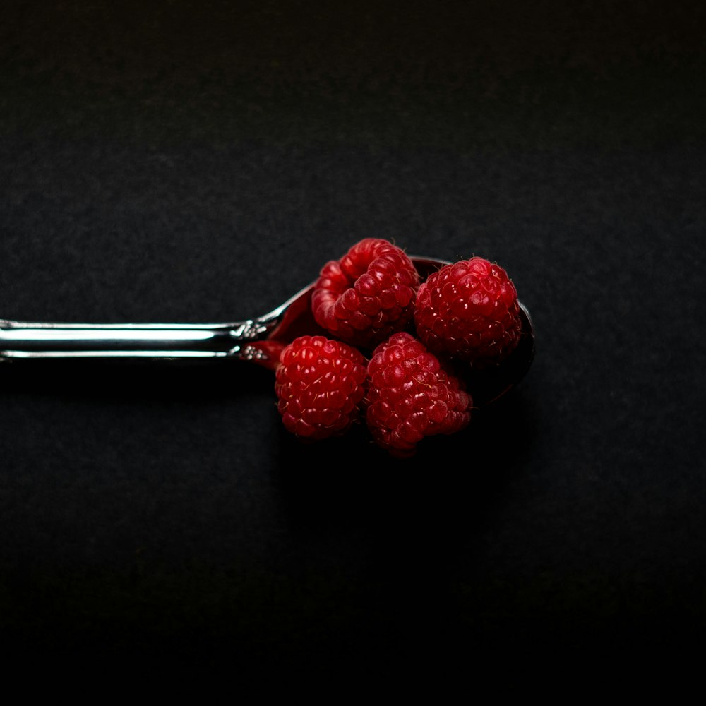 four Strawberry fruits on stainless steel spoon