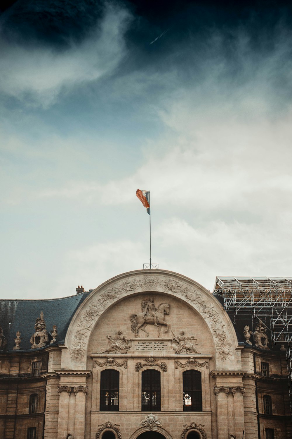 Bandera de mástil completo en el techo del edificio bajo el cielo nublado durante el día