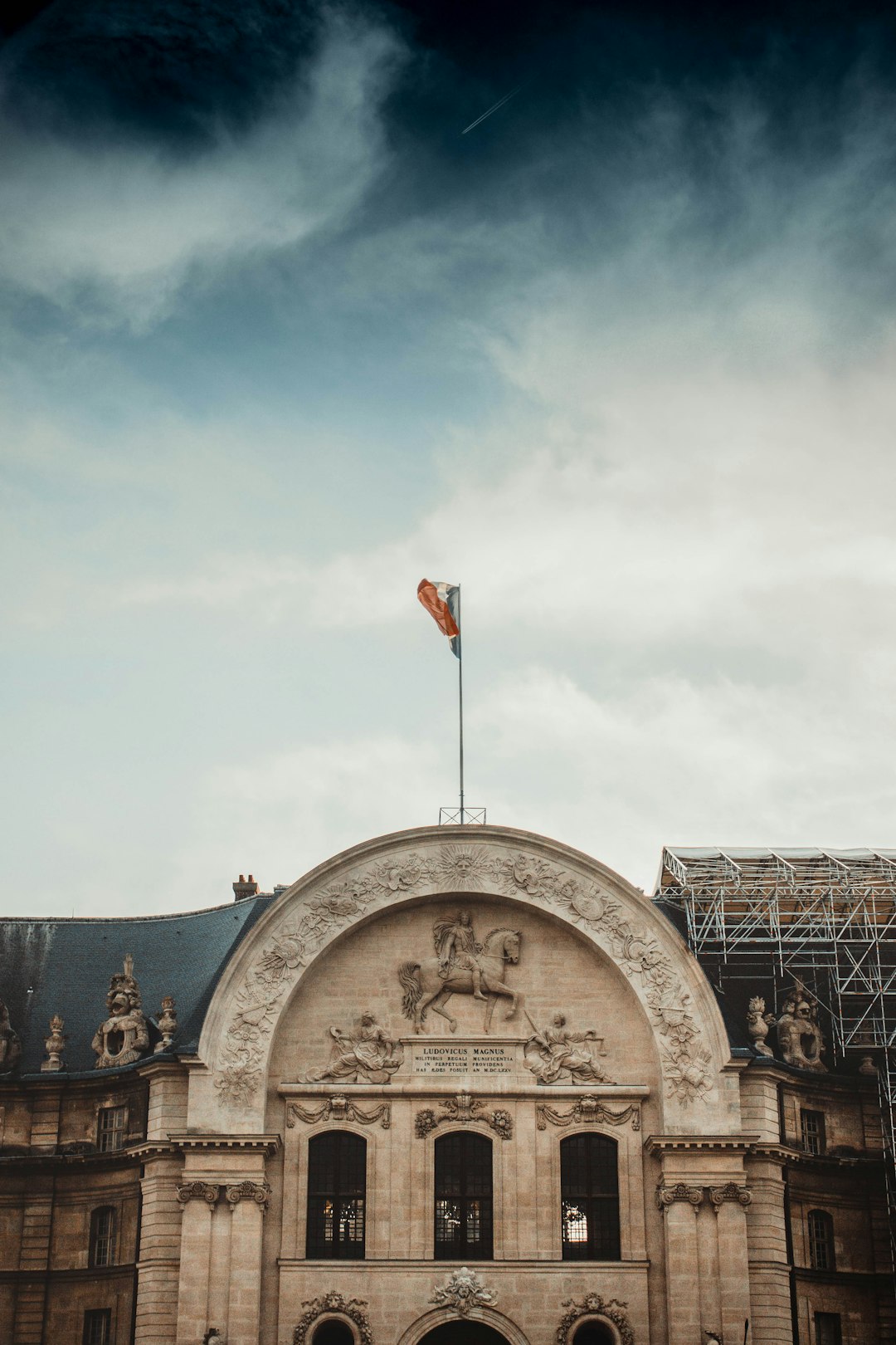 full-mast flag on building roof under cloudy sky during daytime