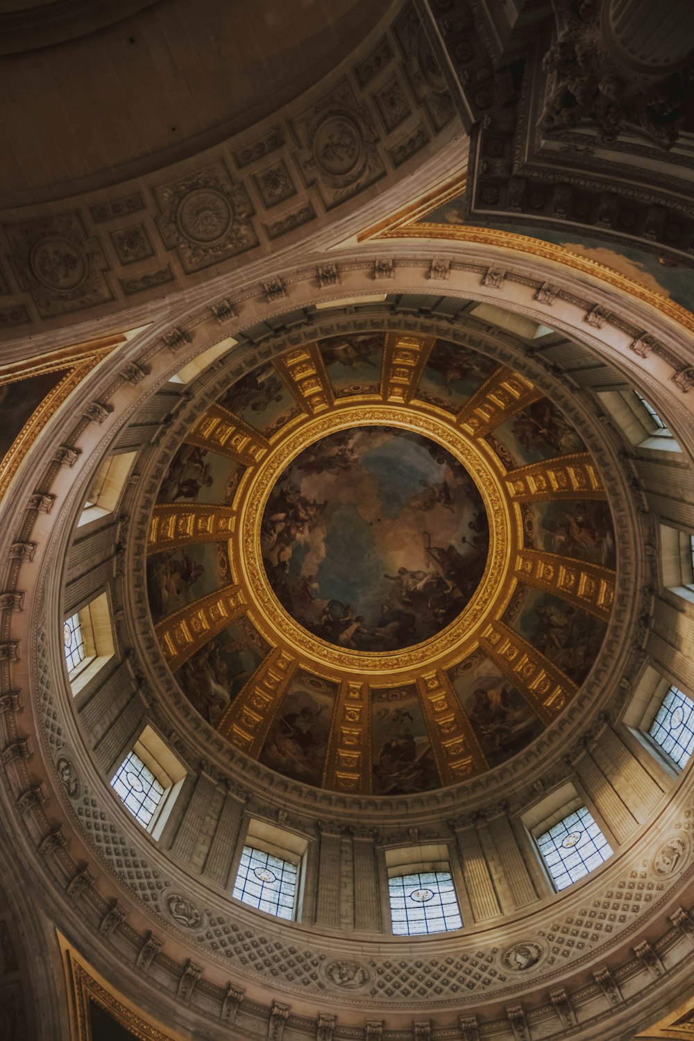 Photographie en contre-plongée des peintures du plafond d’un bâtiment