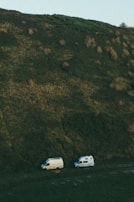 A camper parked on a hilltop with panoramic views of rolling green fields.