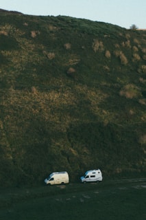 A camper parked on a hilltop with panoramic views of rolling green fields.
