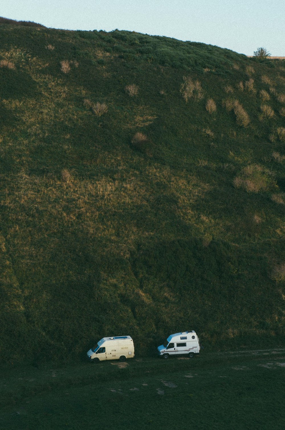Deux camionnettes blanches sous la montagne