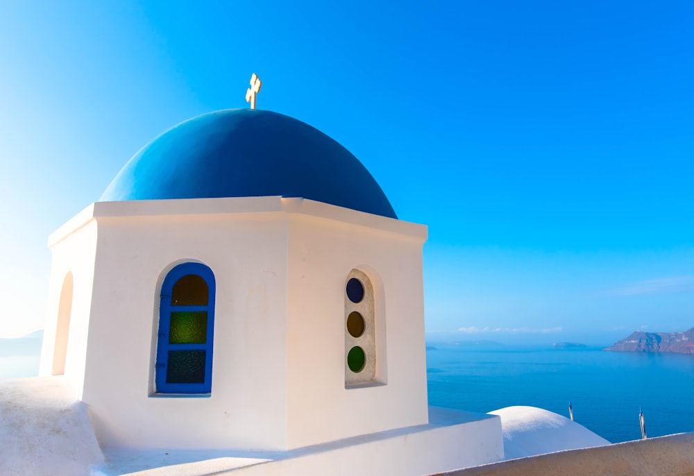 white and blue dome building beside sea