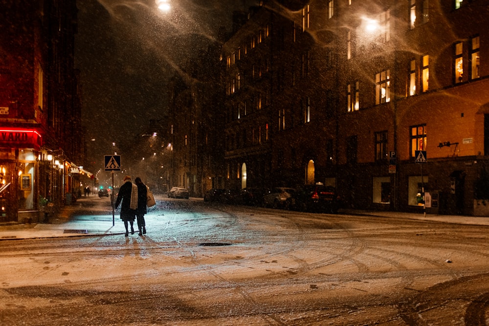 two person walking on street at night