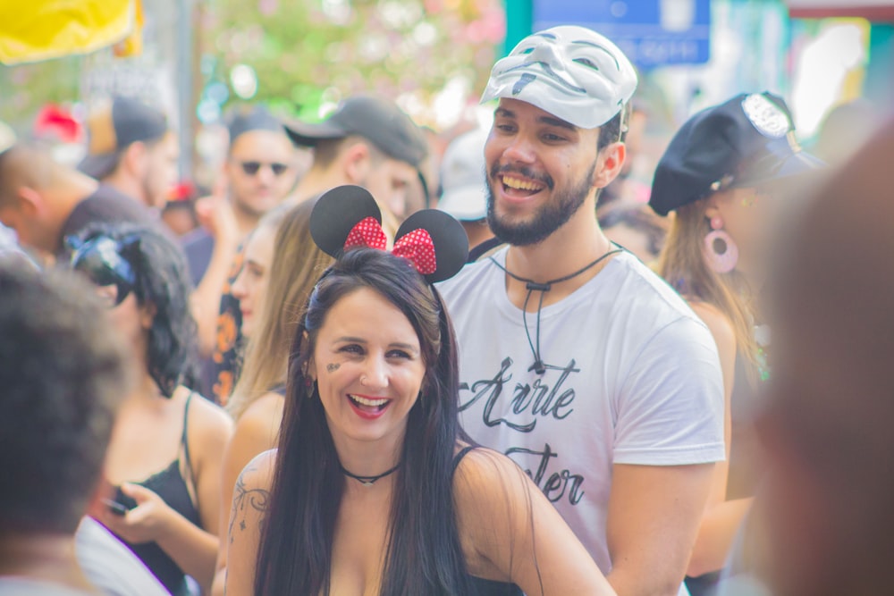 smiling man and woman at crowded street during daytime