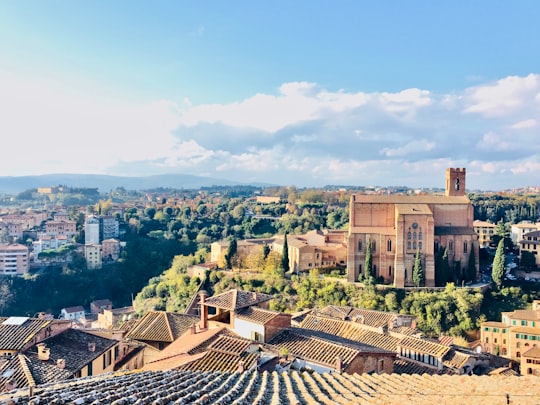 orange concrete building across cloudy sky in Siena Italy