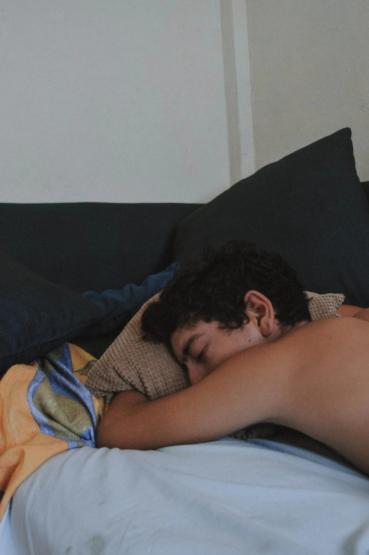 Man lying on his back asleep in bed, illustrating the importance of sleep apnea screening before starting testosterone replacement therapy.