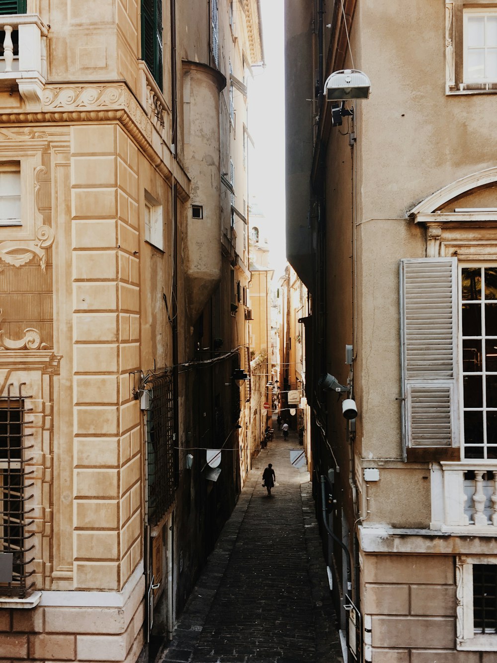 person walking on alley between building during daytime