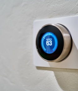 gray Nest thermostat displaying at 63
