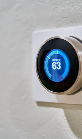 gray Nest thermostat displaying at 63