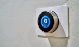 gray Nest thermostat displaying at 63