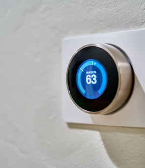 gray Nest thermostat displaying at 63