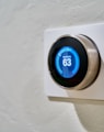 gray Nest thermostat displaying at 63