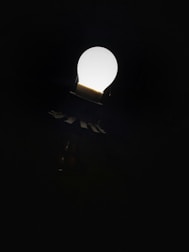 A bright light bulb glowing against a dark background symbolizing ideas.