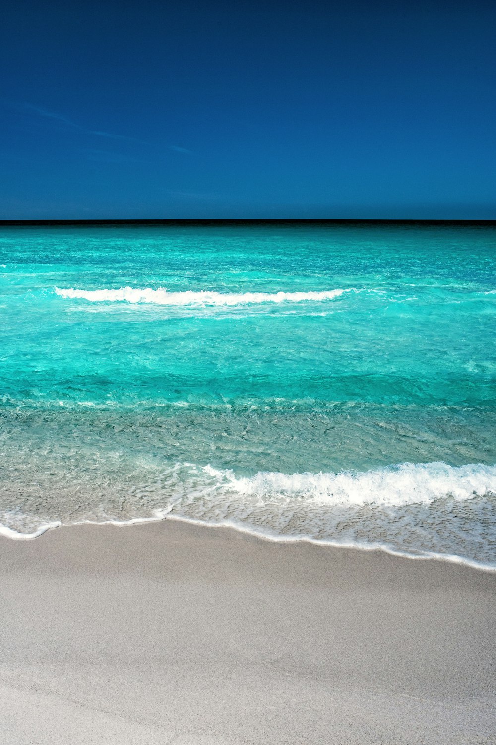 blue beach under clear blue sky