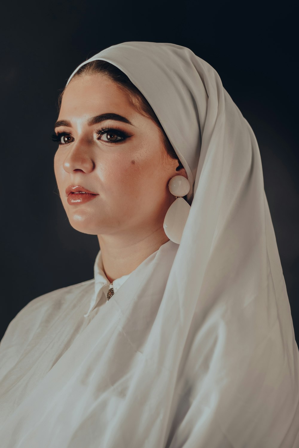 Mujer con vestido blanco y pañuelo hiyab blanco