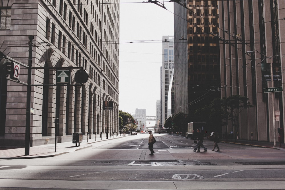 people crossing on road near building