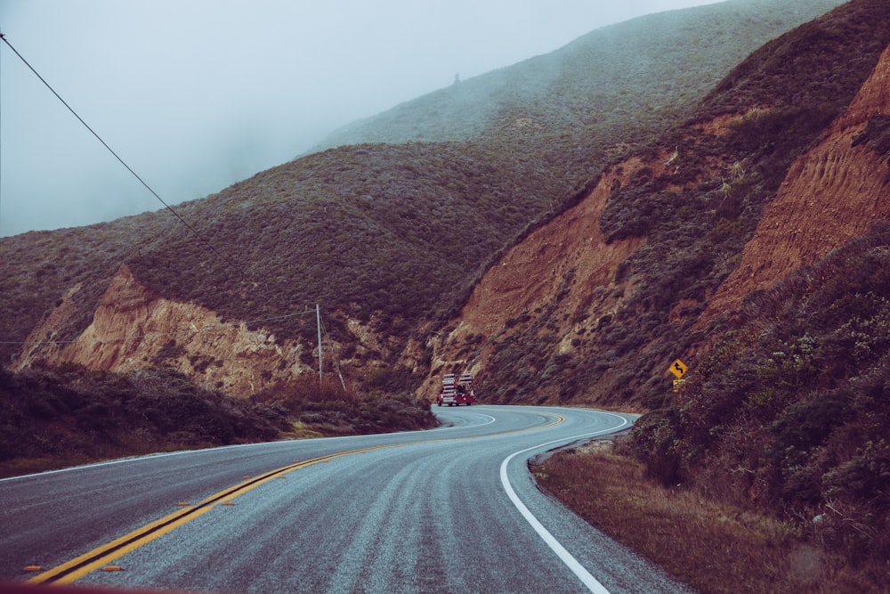 gray asphalt road surrounded by mountains