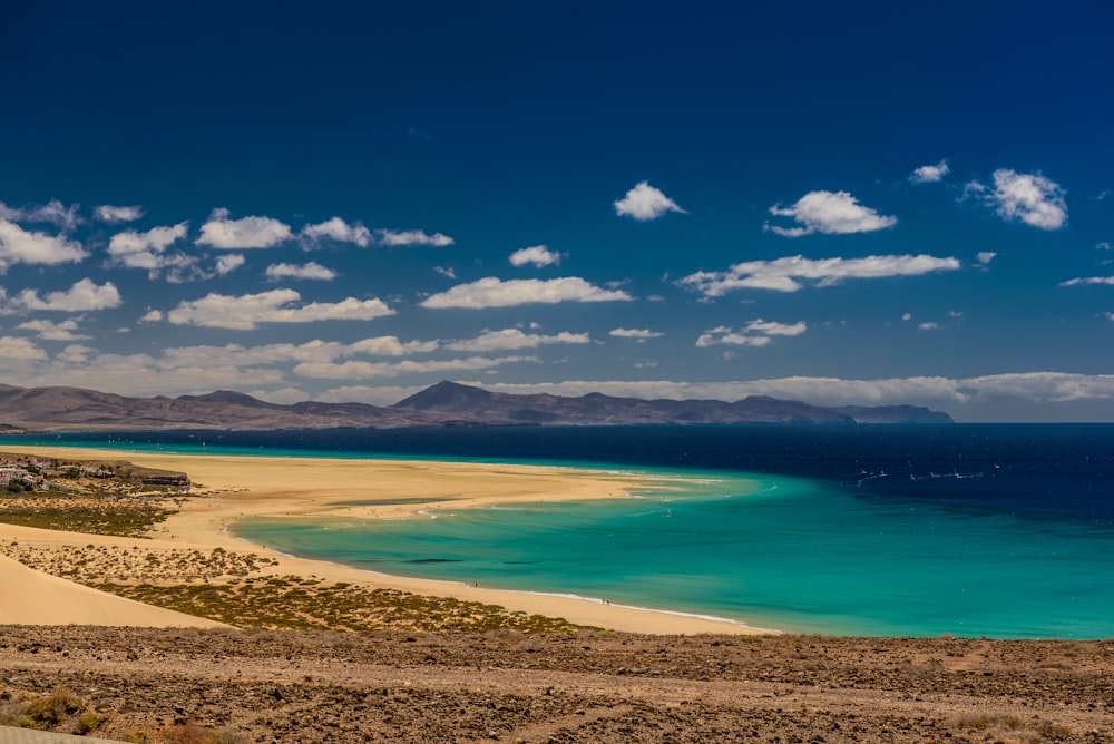 calm body of water under white and blue sky