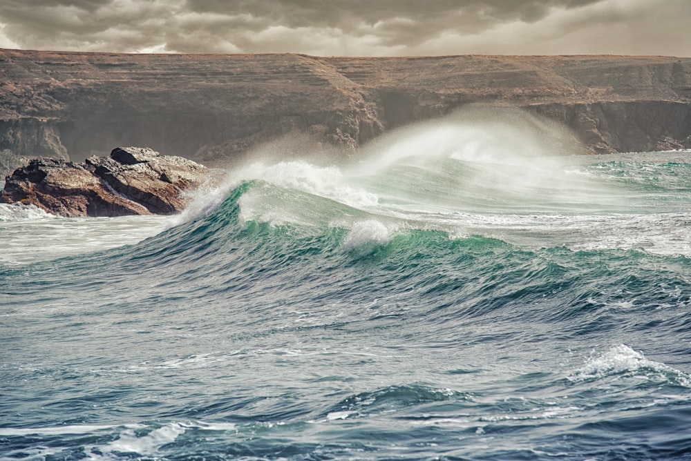 waves crashing through stones