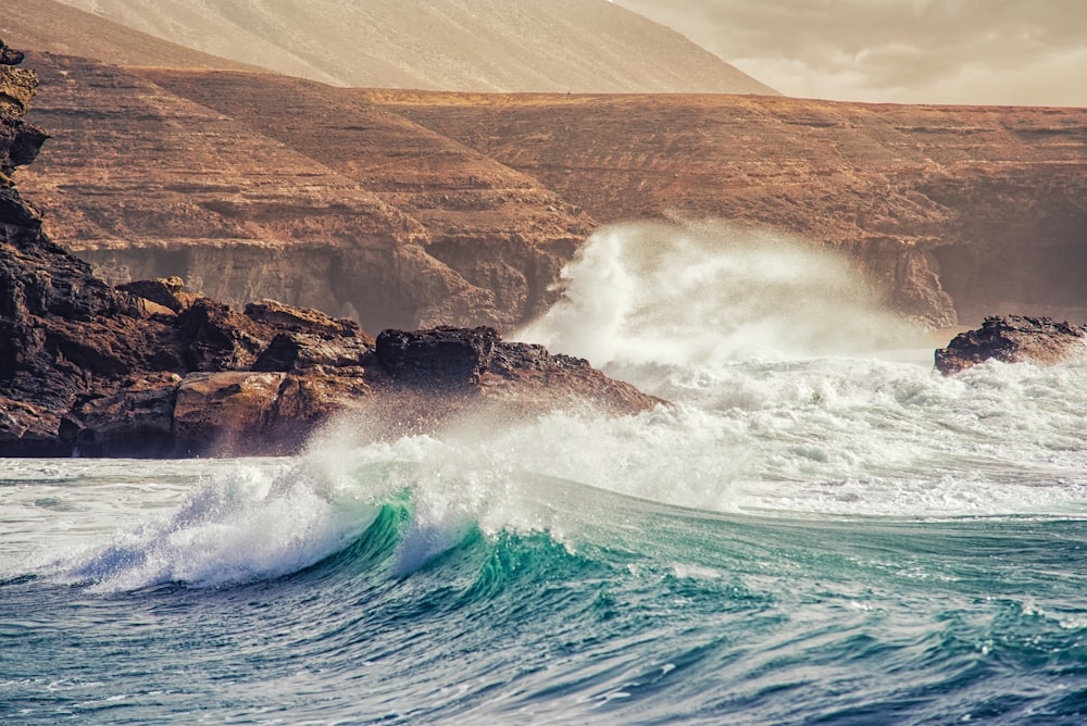 big waves crashing coastal rock during daytime